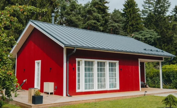 Soome Maja puitelementmaja, Tihane majaprojekt punase puitfassaadi ja valgete ruudustikraamidega akendega.