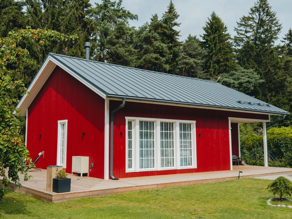 Soome Maja puitelementmaja, Tihane majaprojekt punase puitfassaadi ja valgete ruudustikraamidega akendega.